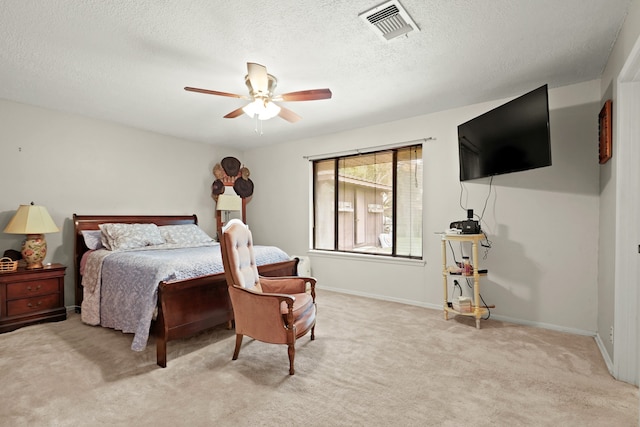 bedroom with ceiling fan, a textured ceiling, and light carpet