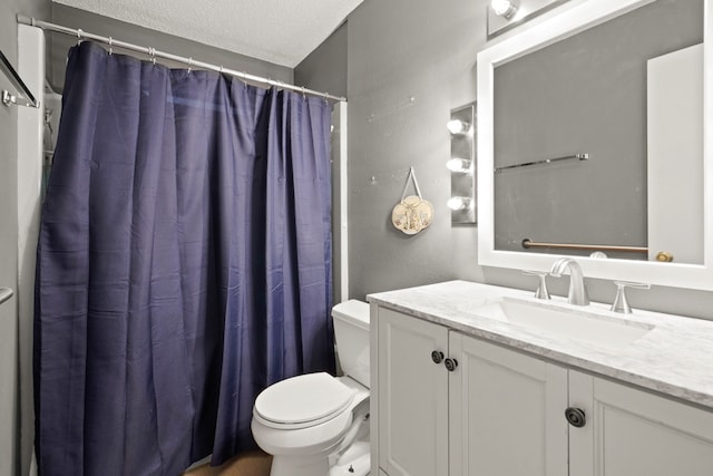 bathroom with a textured ceiling, curtained shower, vanity, and toilet