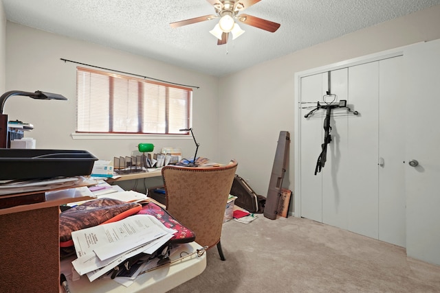 office space with ceiling fan, light colored carpet, and a textured ceiling