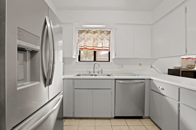 kitchen with gray cabinetry, sink, light tile patterned floors, and stainless steel appliances