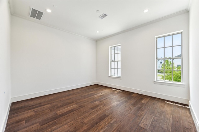 spare room featuring crown molding, dark wood-style flooring, baseboards, and recessed lighting