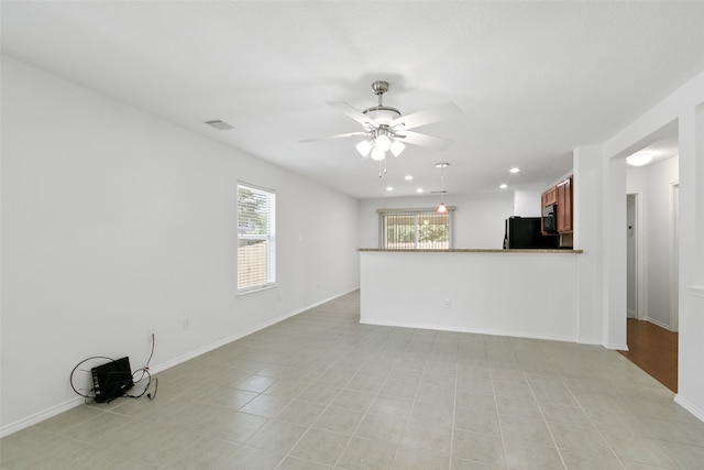 unfurnished living room featuring ceiling fan and light tile patterned floors