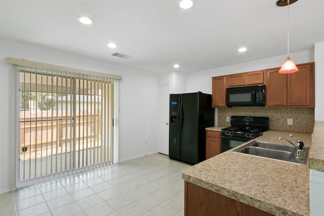 kitchen featuring light tile patterned flooring, hanging light fixtures, sink, black appliances, and decorative backsplash