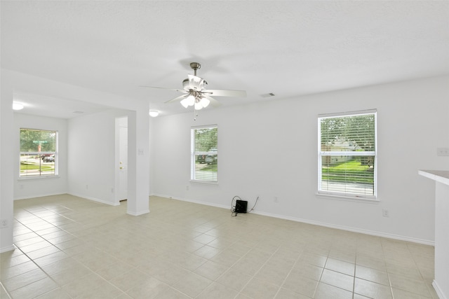 empty room with light tile patterned floors and ceiling fan