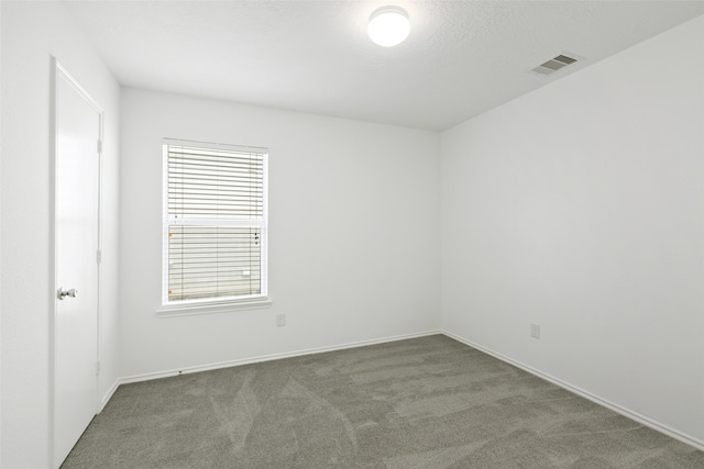 spare room featuring dark carpet