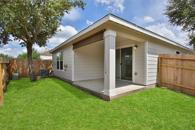 back of house with a lawn and a patio