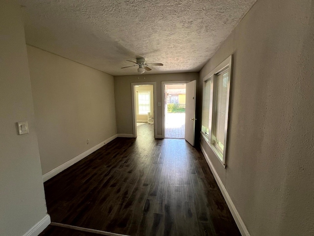 unfurnished room featuring dark wood-type flooring, a textured ceiling, and ceiling fan