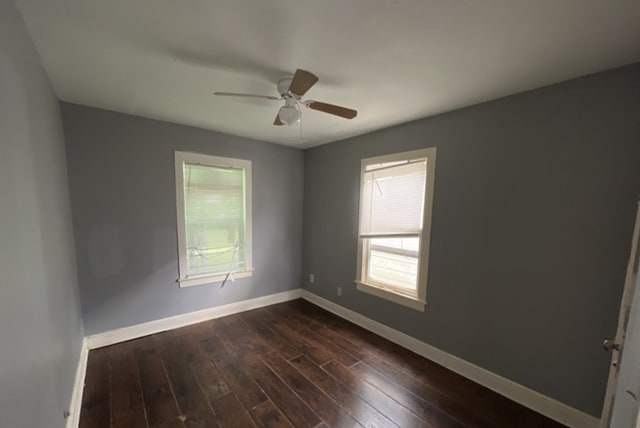 spare room featuring dark wood-type flooring and ceiling fan