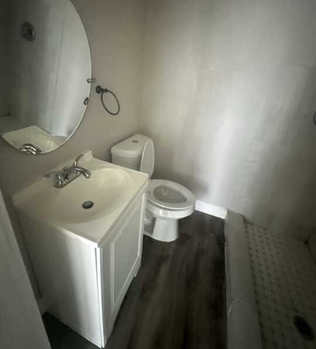 bathroom featuring wood-type flooring, vanity, and toilet