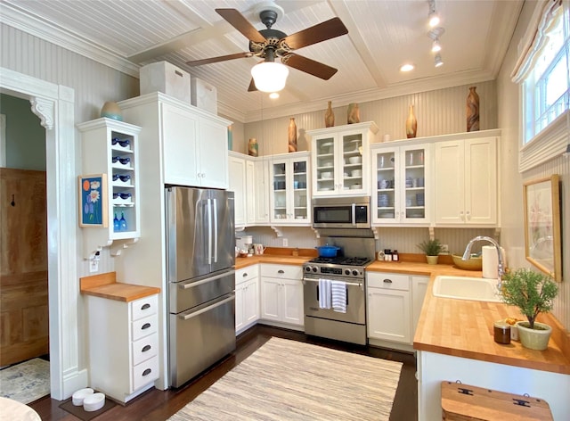 kitchen featuring dark wood finished floors, white cabinets, appliances with stainless steel finishes, a sink, and wood counters