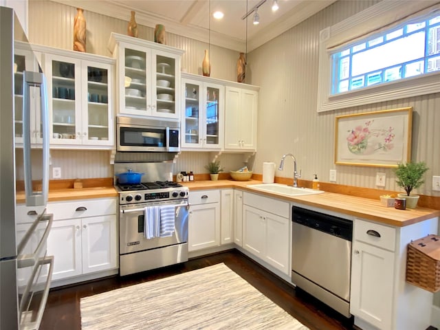 kitchen featuring stainless steel appliances, white cabinets, and butcher block counters