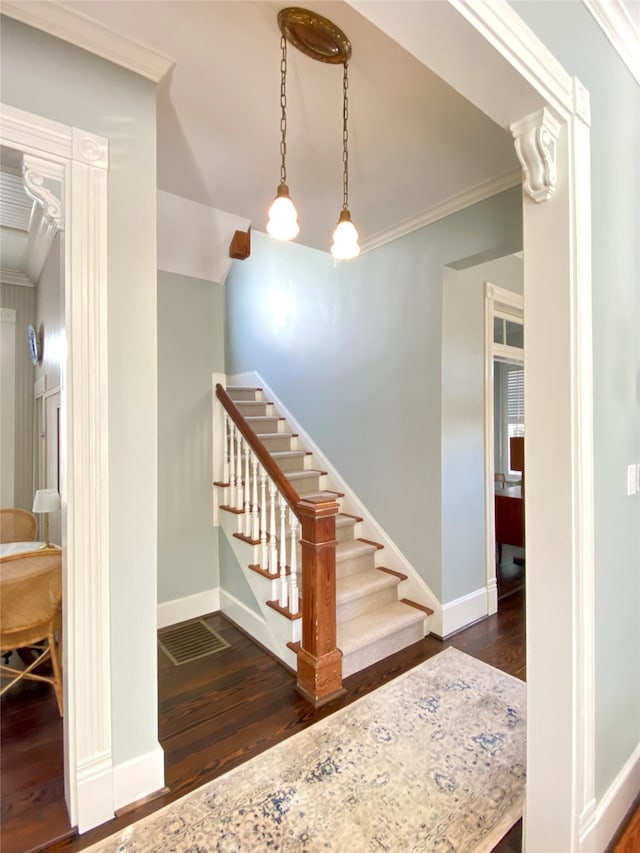 staircase featuring hardwood / wood-style floors and crown molding