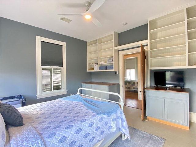 bedroom featuring finished concrete flooring, a ceiling fan, and visible vents