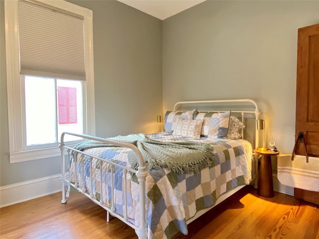 bedroom featuring baseboards and wood finished floors