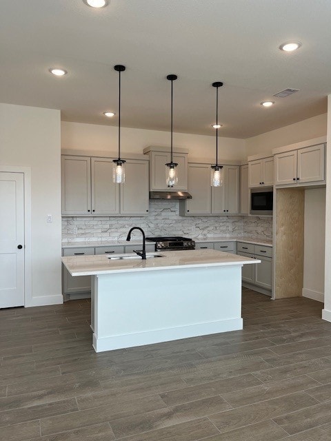 kitchen with gray cabinets, light countertops, a sink, and decorative light fixtures