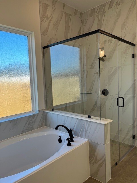 bathroom featuring independent shower and bath