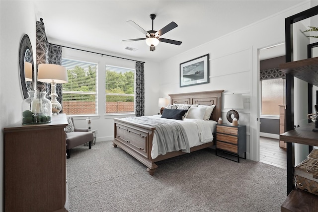 bedroom with baseboards, light colored carpet, visible vents, and a ceiling fan