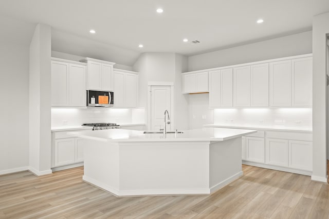 kitchen featuring sink, a kitchen island with sink, stainless steel appliances, and white cabinets