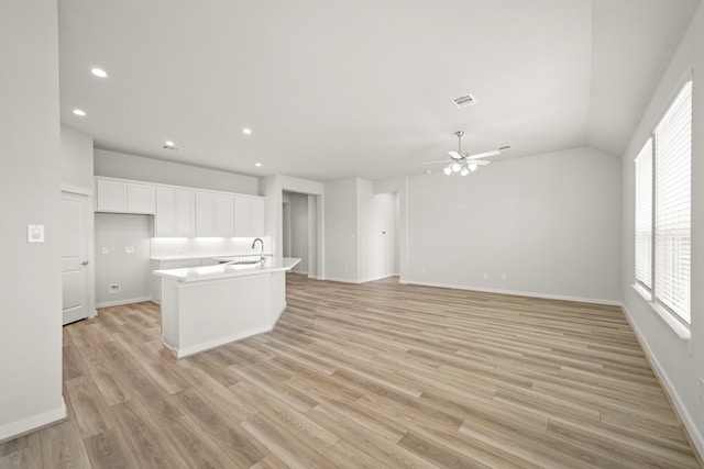 kitchen featuring ceiling fan, an island with sink, white cabinetry, light hardwood / wood-style floors, and sink