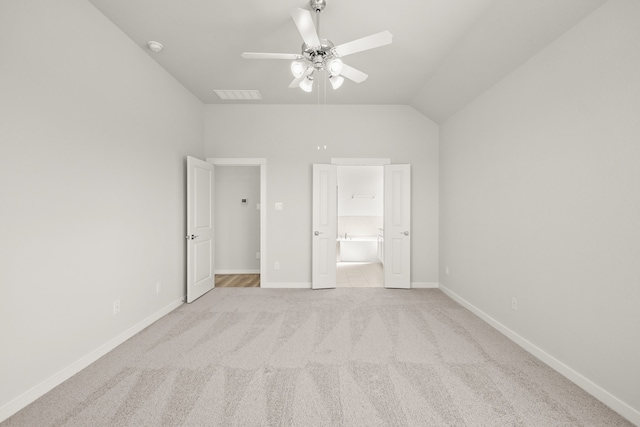 unfurnished bedroom with light carpet, lofted ceiling, connected bathroom, and ceiling fan