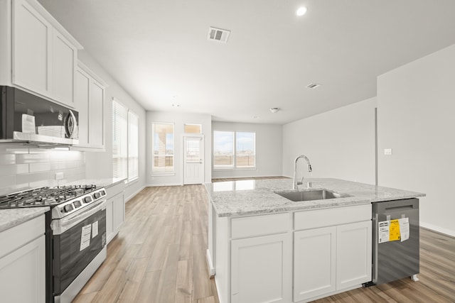 kitchen featuring white cabinetry, light hardwood / wood-style flooring, appliances with stainless steel finishes, and sink