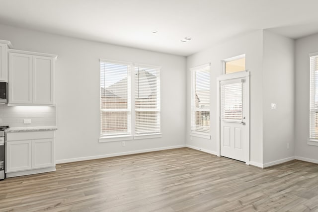 unfurnished dining area featuring light wood-type flooring