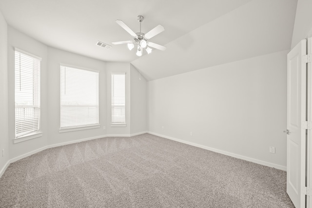 interior space featuring vaulted ceiling, carpet flooring, and plenty of natural light