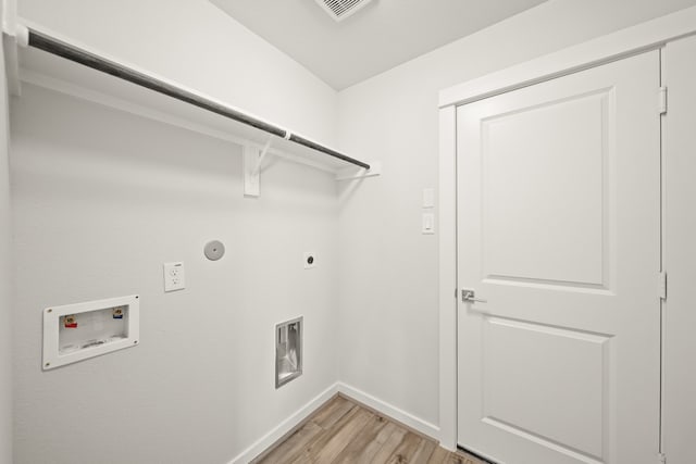 clothes washing area featuring gas dryer hookup, light hardwood / wood-style flooring, electric dryer hookup, and washer hookup