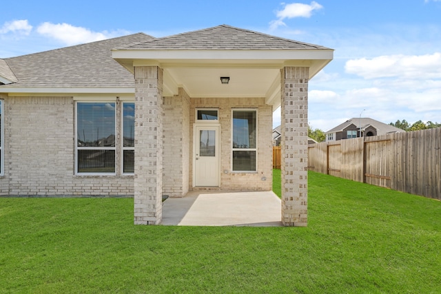 rear view of house featuring a yard and a patio