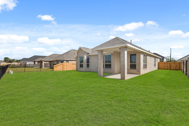 back of house with a yard and a patio area