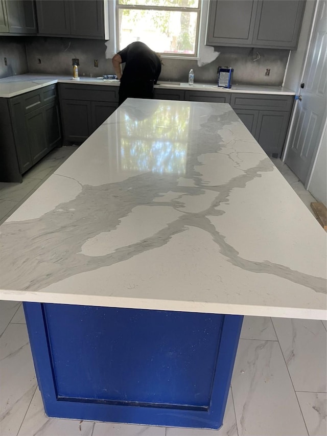 5526 Maywood Dr, Houston, TX 77053 - kitchen featuring marble finish floor, light stone countertops, a spacious island, and backsplash