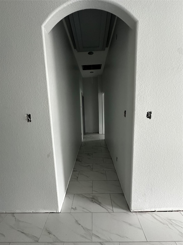 5526 Maywood Dr, Houston, TX 77053 - hallway with marble finish floor, arched walkways, and a textured wall