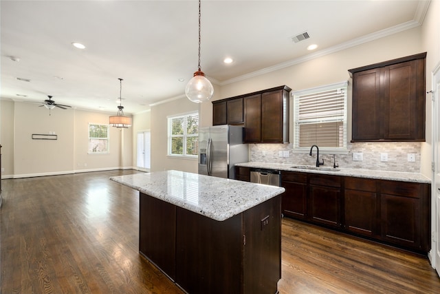 kitchen featuring appliances with stainless steel finishes, a center island, sink, and dark hardwood / wood-style flooring