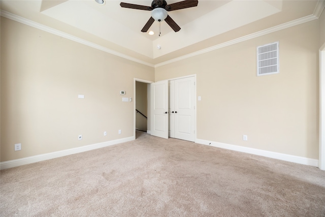 spare room with ceiling fan, a raised ceiling, and crown molding