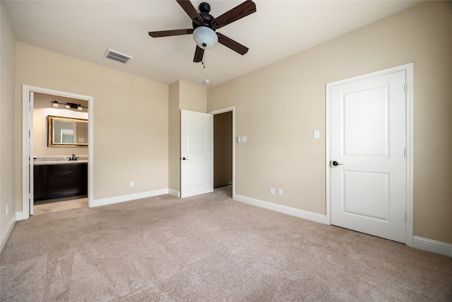 unfurnished bedroom featuring connected bathroom, ceiling fan, and light colored carpet