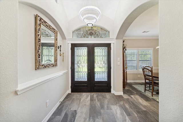 foyer entrance featuring french doors, vaulted ceiling, crown molding, and wood-type flooring