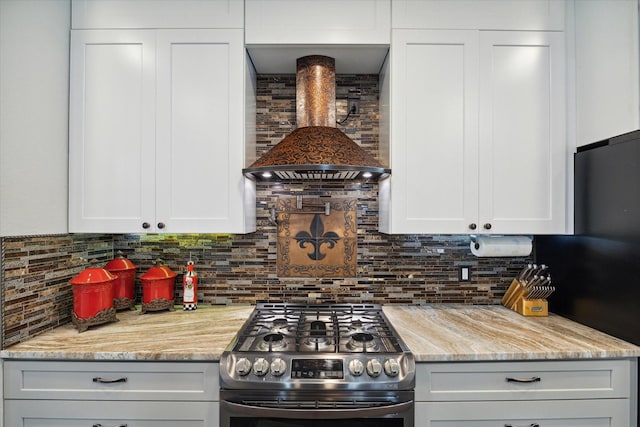 kitchen with stainless steel appliances, white cabinets, backsplash, and wall chimney range hood