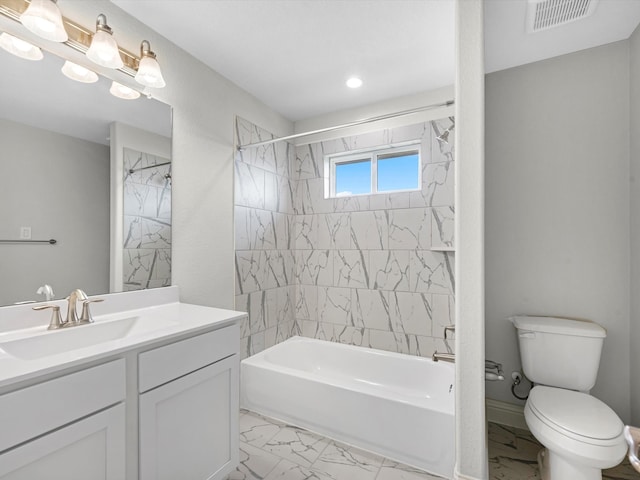 full bathroom featuring vanity, tiled shower / bath combo, and toilet