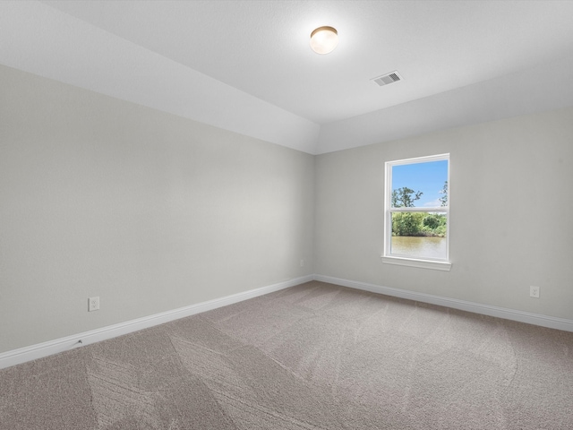 unfurnished room with carpet and lofted ceiling