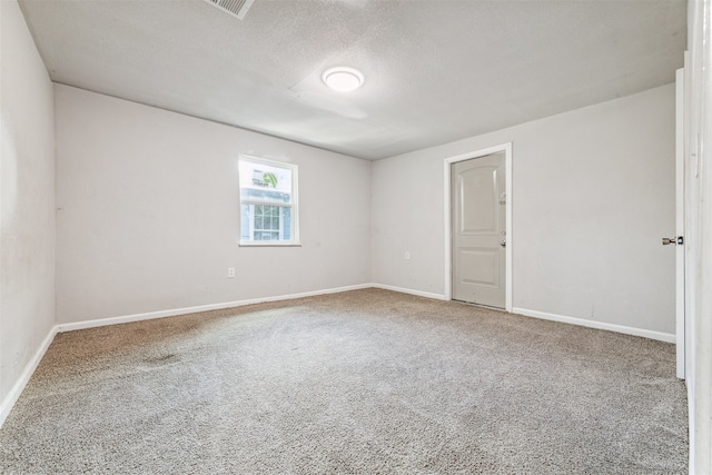 carpeted spare room featuring a textured ceiling