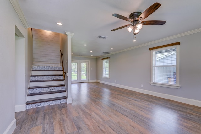 unfurnished living room with crown molding, dark wood-type flooring, ceiling fan, and french doors