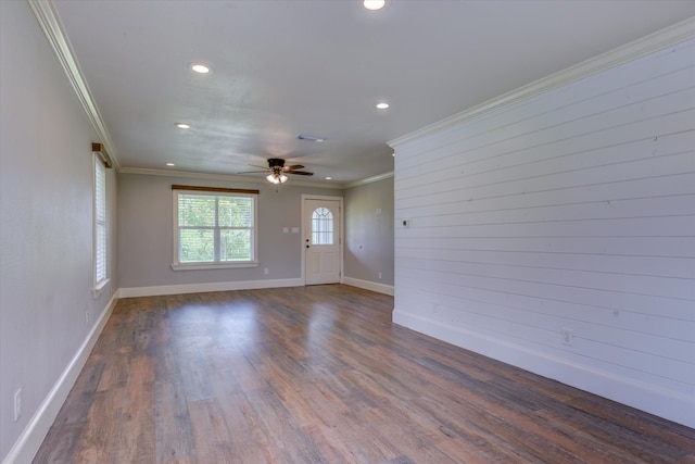 empty room featuring ornamental molding, ceiling fan, and dark wood-type flooring