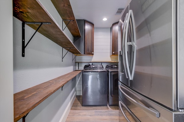 kitchen with light hardwood / wood-style floors, stainless steel fridge, independent washer and dryer, and wood counters