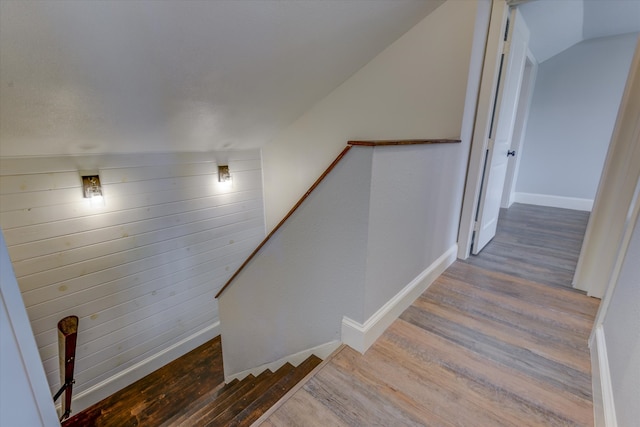 staircase with lofted ceiling and hardwood / wood-style floors