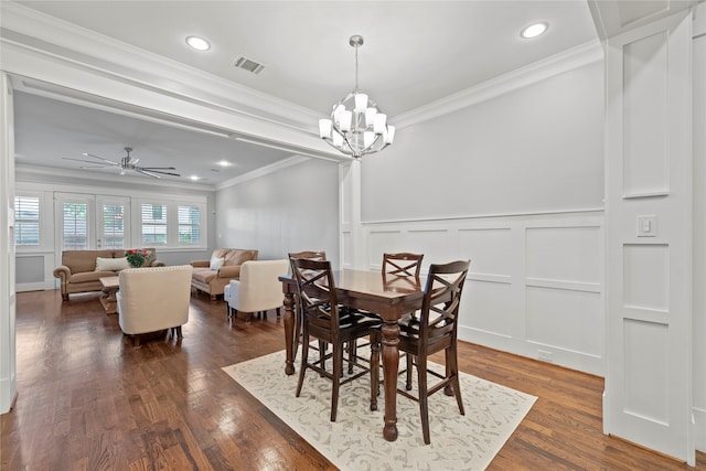 dining space with ornamental molding, ceiling fan with notable chandelier, and dark hardwood / wood-style flooring