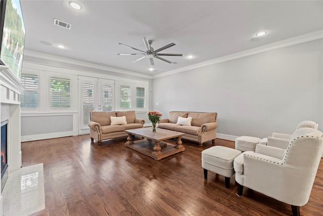 living room with a fireplace, crown molding, and dark hardwood / wood-style flooring