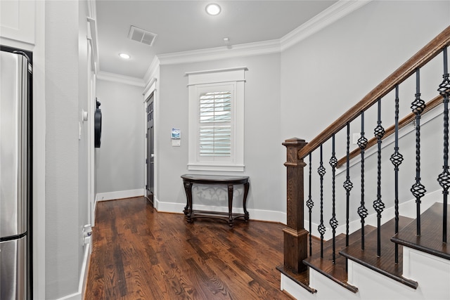 foyer with dark hardwood / wood-style floors and crown molding