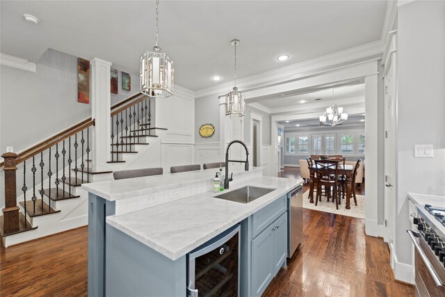 kitchen with a kitchen island with sink, stainless steel appliances, dark wood-type flooring, beverage cooler, and sink