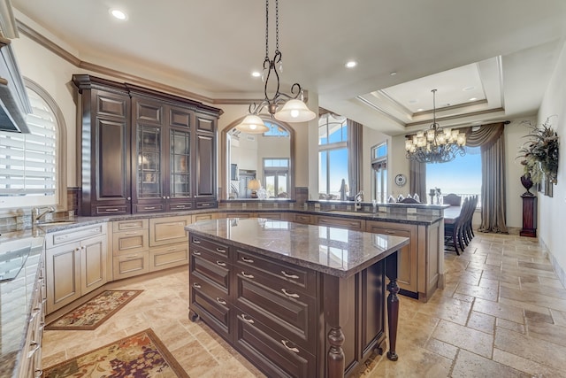 kitchen with dark brown cabinetry, pendant lighting, kitchen peninsula, and a center island