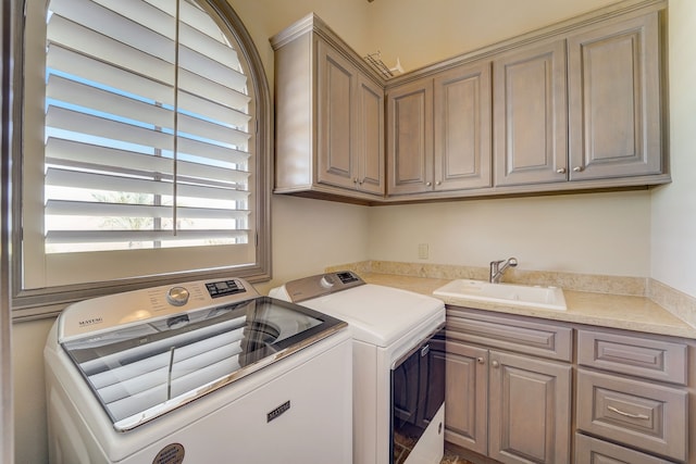 washroom featuring cabinets, sink, and washing machine and clothes dryer